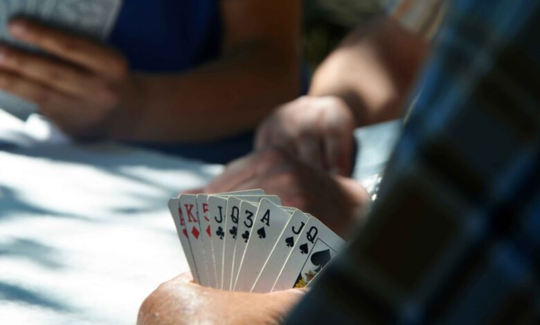 Players holding sets of cards in their hands