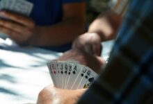 Players holding sets of cards in their hands