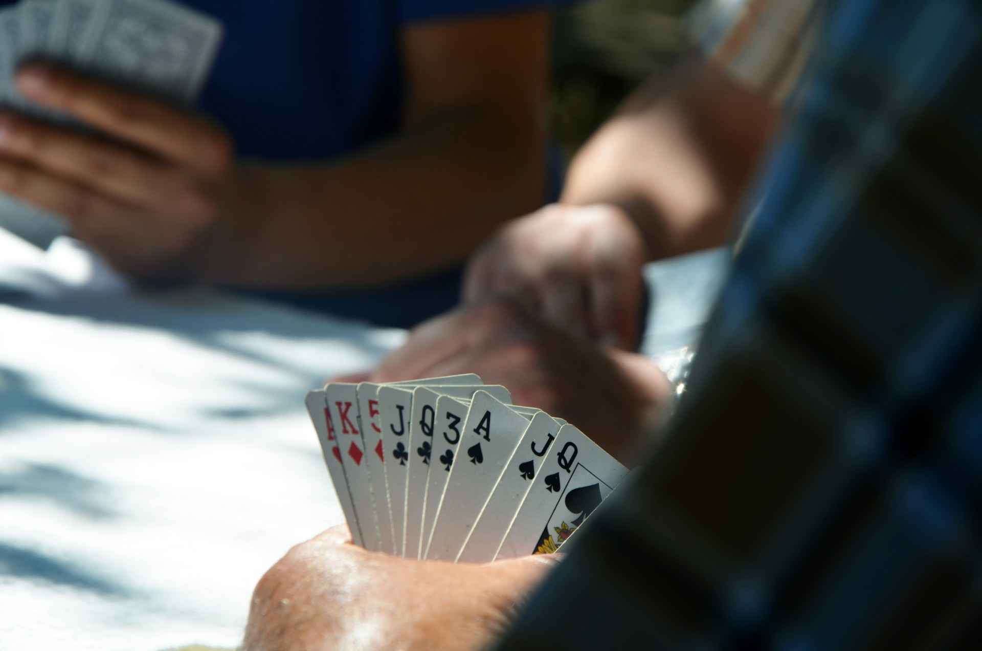 Players holding sets of cards in their hands